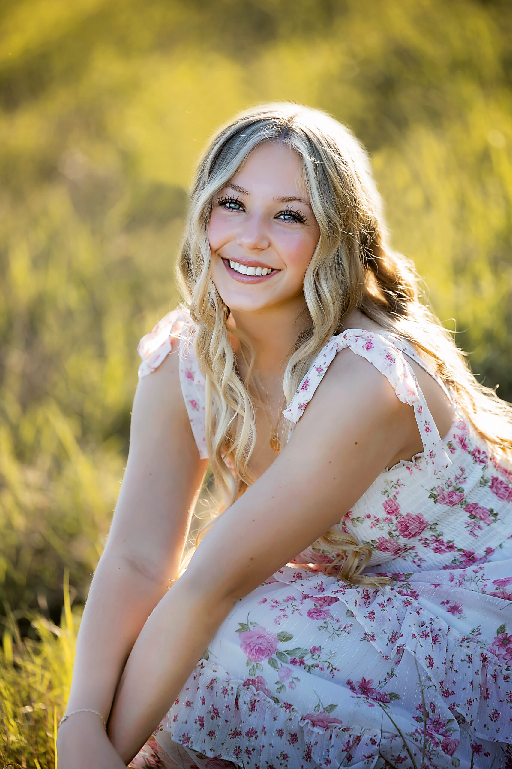 blond girl with light floral dress in field on spring day